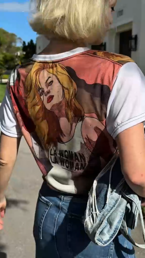 Load image 1 in gallery view. Person wearing a t-shirt with a graphic design of a woman on the back.